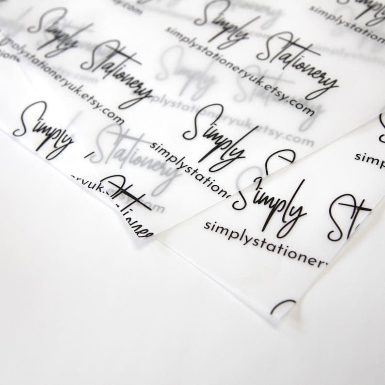 May include: Close-up of a stack of clear plastic sheets with the text "Simply Stationery" and the website address "simplystationeryuk.etsy.com" printed on them.