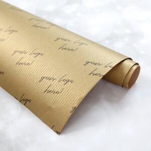 K&ouml;nnte beinhalten: Eine Rolle braunes Kraftpapier Geschenkpapier mit einem sich wiederholenden Muster des Textes "Ihr Logo hier!" in Schwarz gedruckt.