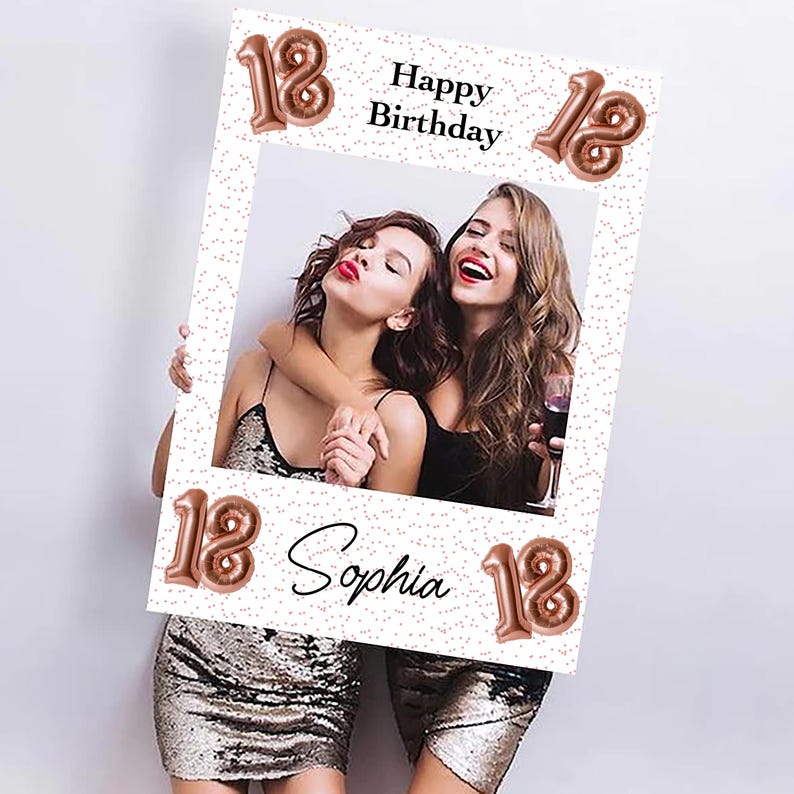 Op de afbeelding: Een witte fotolijst met de tekst "Happy Birthday" en "Sophia" in zwart schrift. Het nummer "18" wordt herhaald in ros&eacute;gouden ballonlettertype. Twee vrouwen staan in de lijst, glimlachen en omarmen elkaar. De lijst heeft een stippenpatroon.