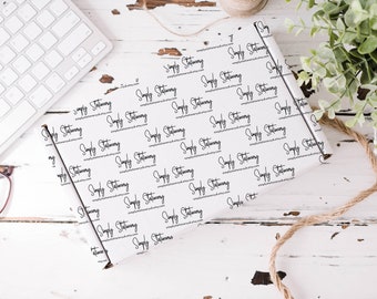 May include: White wrapping paper with a repeating pattern of the text "Simply Stationery" in black cursive font.