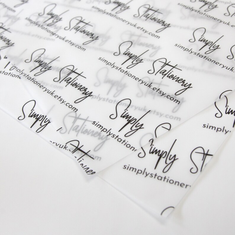 May include: Close-up of a stack of clear, translucent tissue paper with the text "Simply Stationery" repeated in black cursive writing. The text also includes the website address "simplystationeryuk.etsy.com".