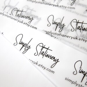 May include: Close-up of a clear plastic business card with the text "Simply Stationery" and the website address "simplystationeryuk.etsy.com" printed in black.