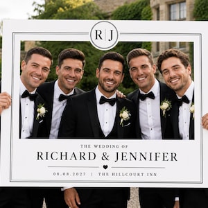 Può includere: Una cornice rettangolare bianca per cabina fotografica con bordo nero, recante il testo "THE WEDDING OF RICHARD & JENNIFER", la data "08.08.2027", "THE HILLCOURT INN" e un monogramma circolare con le lettere "R | J" al centro in alto.