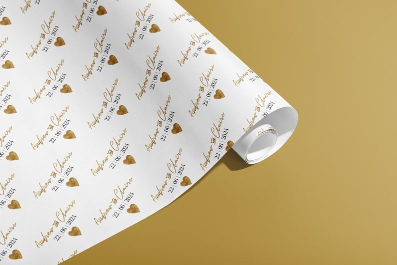 K&ouml;nnte beinhalten: Wei&szlig;es Geschenkpapier mit einem sich wiederholenden Muster aus goldenen Herzen und dem Text "Andrew & Claire 22/06/2024".