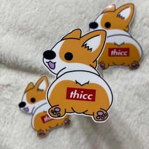 May include: Three cartoon stickers of a corgi dog with the word "thicc" printed on its rear end. The corgi is brown and white with a pink tongue sticking out.