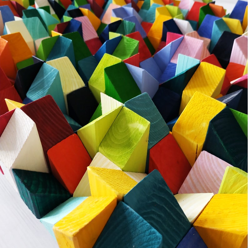 May include: A wall art piece made of colourful wooden blocks arranged in a geometric pattern. The blocks are painted in various shades of green, blue, red, yellow, and white.