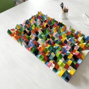 May include: A colourful geometric wall art piece made of wood. The piece is made up of many small, triangular shapes in a variety of colours, including red, orange, yellow, green, blue, and purple.