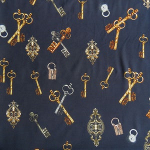 Könnte beinhalten: Ein dunkelblauer Stoff mit einem sich wiederholenden Muster aus goldenen Schlüsseln, Anhängern und verzierten Designs. Die Schlüssel sind in verschiedenen Formen und Größen, und die Anhänger sind mit komplizierten Details verziert.