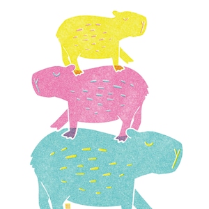 Könnte beinhalten: Eine skurrile Illustration von drei aufeinander gestapelten Wasserschweinen. Das untere Wasserschwein ist hellblau, das mittlere rosa und das obere gelb. Jedes hat ein strukturiertes Aussehen vor weißem Hintergrund.