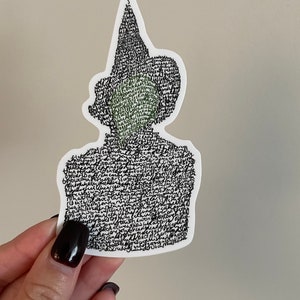 Könnte beinhalten: Ein schwarz-weißer Aufkleber einer Person mit Hut. Das Gesicht der Person ist mit schwarz-weißem Text gefüllt. Der Hut ist ebenfalls mit schwarz-weißem Text gefüllt. Der Aufkleber befindet sich auf einem weißen Hintergrund.