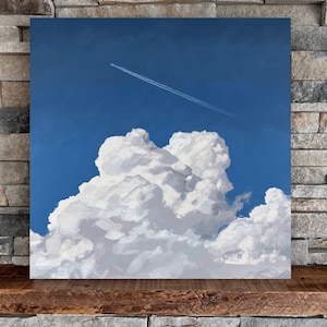 May include: A painting of a large, fluffy white cloud against a bright blue sky. A white airplane contrail streaks across the sky.