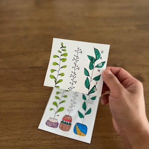 Puede incluir: Tres ilustraciones de plantas diferentes con hojas y tallos verdes. Las plantas están en macetas con diseños coloridos. La palabra "GROW" está escrita verticalmente en el lado derecho de la imagen.