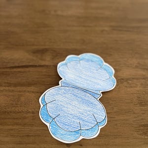 Może przedstawiać: Wycięty z papieru niebieski muszelka z fakturowanym wzorem. Muszelka jest otwarta i ma białe wnętrze.
