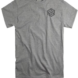 May include: A heather gray short-sleeve t-shirt featuring a black line art graphic of a twenty-sided die on the upper left chest. The die displays various numbers including a prominent twenty at the top center, rendered in a clean, minimalist style.