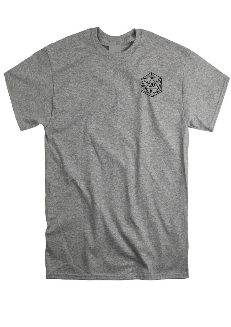 May include: A heather gray short-sleeve t-shirt featuring a black line art graphic of a twenty-sided die on the upper left chest. The die displays various numbers including a prominent twenty at the top center, rendered in a clean, minimalist style.