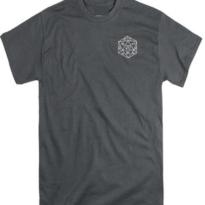 May include: A dark charcoal gray short-sleeve t-shirt featuring a white line-art graphic of a twenty-sided die on the upper left chest. The die displays the number 20 at the top, with other visible numbers including 8, 2, 14, 4, and 9.