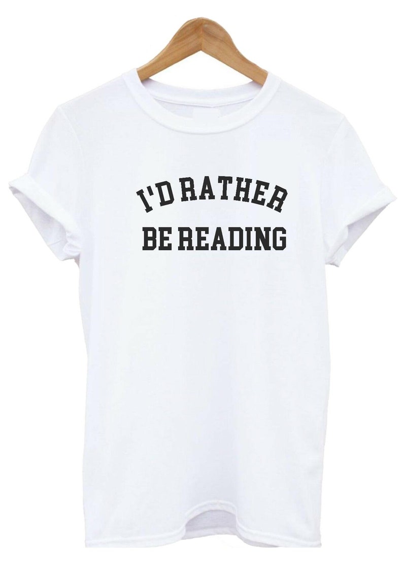 May include: White t-shirt with black text that reads "I'd rather be reading".