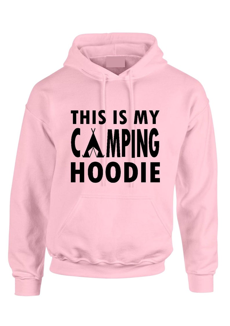 May include: A light pink hoodie with a front pocket and a drawstring hood. The black text on the front reads "THIS IS MY CAMPING HOODIE" with a tent graphic. The hoodie is made of a soft material.
