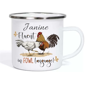 Può includere: Tazza di smalto bianco con un'illustrazione di un gallo e una gallina. Il testo sulla tazza recita "Janine Fluent in FOWL language!"