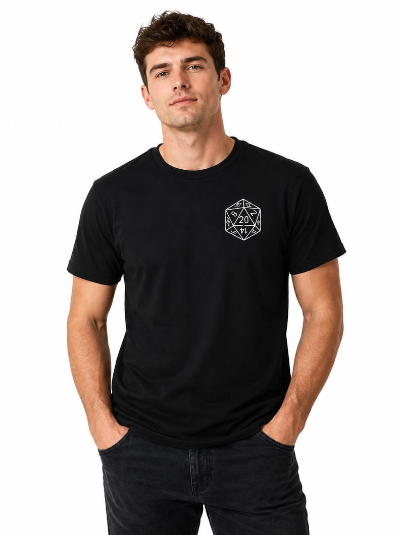 May include: A black short-sleeved t-shirt featuring a white line art graphic of a twenty-sided die on the left chest. The die design displays various numbers, with the number 20 prominently centered within the geometric shape of the polygon.