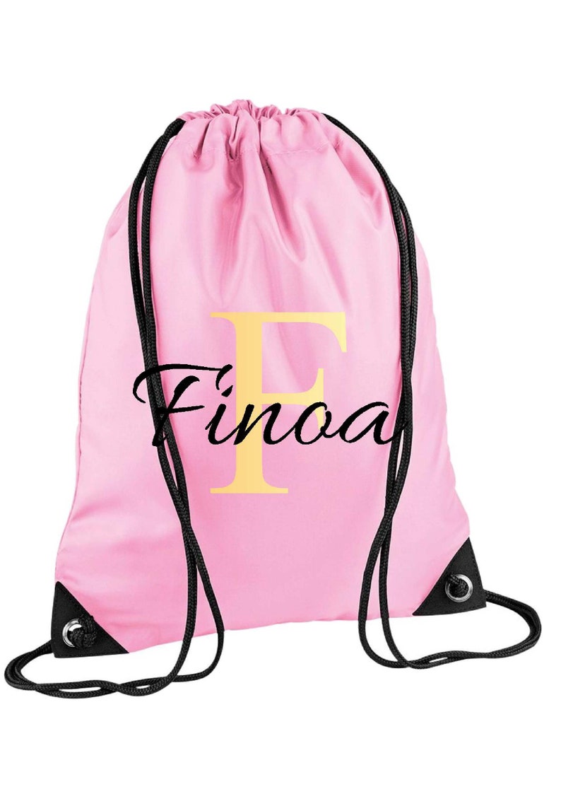 drawstring waterproof bag in pale pink colour , with a gold monogram letter and script name