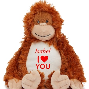 May include: A plush brown monkey with a white belly. The text "Isabel I ❤️ YOU" is printed on the belly in red. The monkey has a smiling face and is sitting down.
