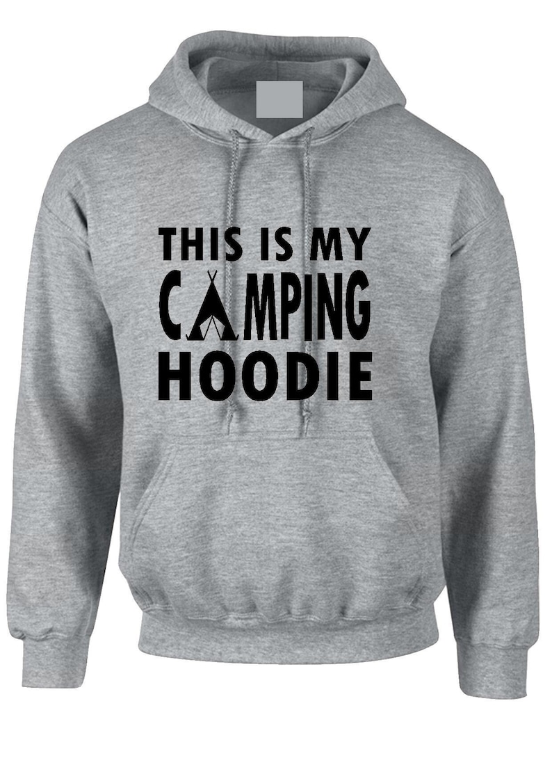 May include: A gray hooded sweatshirt with the text "THIS IS MY CAMPING HOODIE" in black. The design includes a tent graphic. The hoodie has a front pocket and a drawstring hood.