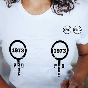 Puede incluir: Camiseta blanca con un diseño gráfico negro. El diseño incluye el año "1973" dentro de un círculo, con la palabra "PRO" debajo. La camiseta también tiene iconos "SVG" y "PNG".