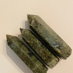 May include: Three green moss agate crystal points, also known as green phantom quartz, with a natural, raw, and unpolished finish.