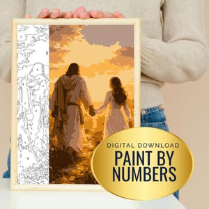 May include: A paint-by-numbers kit depicting a religious scene of two figures walking towards a sunset. The kit includes a framed canvas with a numbered outline and a golden oval with the text "DIGITAL DOWNLOAD PAINT BY NUMBERS".