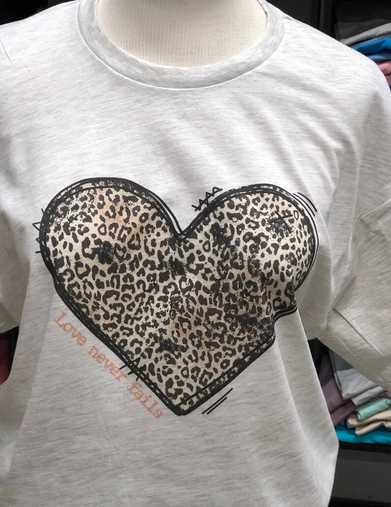 Love never fails leopard heart graphic t-shirt