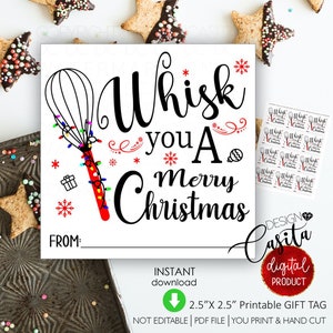 Op de afbeelding: Een wit cadeaulabel met de tekst "Whisk you A Merry Christmas" in het zwart. De gardehandgreep is rood en versierd met kleurrijke lichtjes. Bevat een ruimte om "FROM:" te schrijven en een kleiner vel met bijpassende labels.