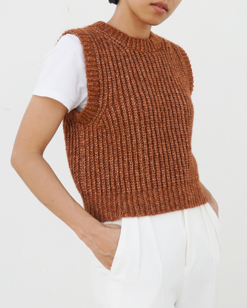 K&ouml;nnte beinhalten: Eine braune, gestrickte, &auml;rmellose Strickweste mit Rippenstruktur.