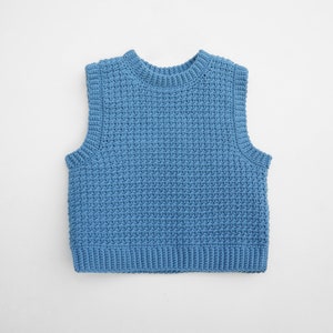Può includere: Un gilet di maglia blu senza maniche con una trama a nido d'ape.