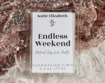 May include: A clear plastic container of soy wax melts with the text "Endless Weekend." The label reads "Katie Elizabeth" and "Natural Soy Wax Melts." The container is 2.5 oz. (71 g).