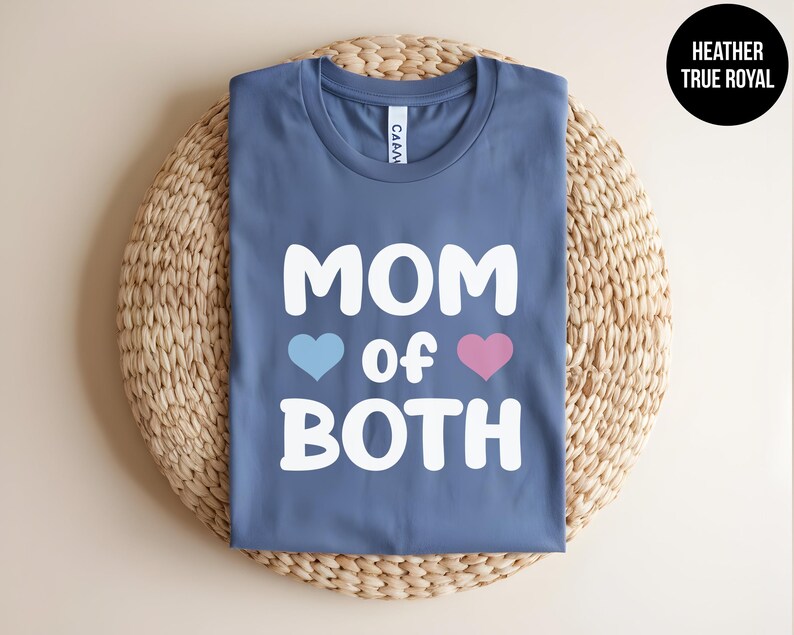 May include: A blue t-shirt with the text "MOM of BOTH" in white, with a blue heart and a pink heart on either side of the word "of".
