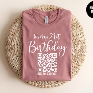 May include: A heather mauve t-shirt with the text "It's My 21st Birthday" and a QR code that says "Buy Me A Drink!"