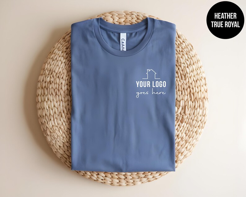 May include: A heather true royal blue t-shirt with a white outline of a house and the text "YOUR LOGO goes here".