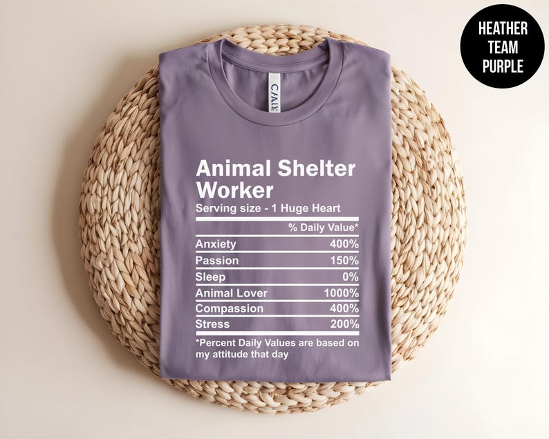 May include: A purple t-shirt with a white graphic that reads "Animal Shelter Worker" and lists the daily value of anxiety, passion, sleep, animal lover, compassion, and stress. The graphic is styled like a nutrition label.