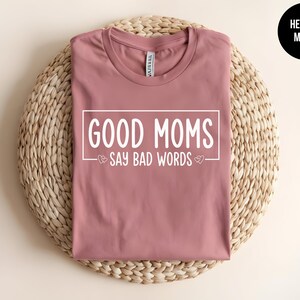 May include: Heather mauve t-shirt with the text "Good Moms Say Bad Words" printed in white.