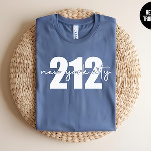 May include: A blue t-shirt with white text that says "new york city 212".