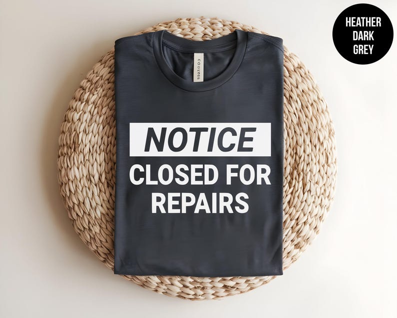 May include: Heather dark grey t-shirt with white text that reads "NOTICE CLOSED FOR REPAIRS".