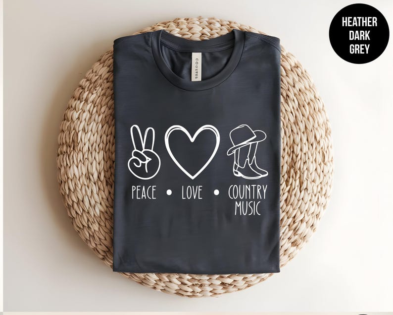 May include: Heather dark grey t-shirt with a white peace sign, heart, cowboy hat and boots graphic and the text "Peace. Love. Country Music."