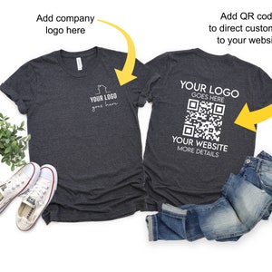 May include: A dark gray t-shirt with a white logo on the front and a QR code on the back. The text on the back reads "YOUR LOGO GOES HERE" and "YOUR WEBSITE MORE DETAILS".