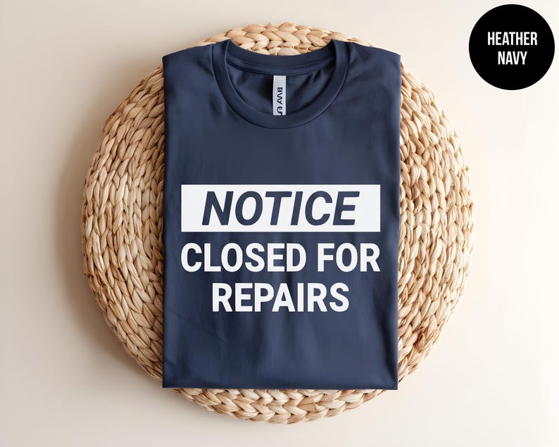 May include: A heather navy blue t-shirt with a white rectangle that says "NOTICE CLOSED FOR REPAIRS".