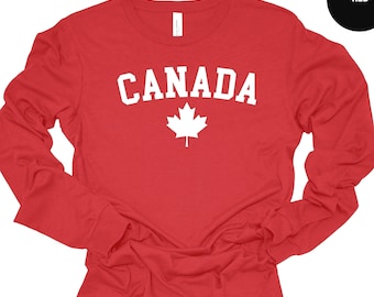 May include: Red long-sleeve shirt with the word "CANADA" in white text and a white maple leaf.