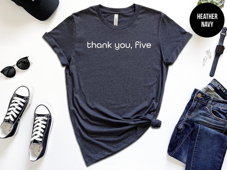 May include: A heather navy blue t-shirt with the text "thank you, five" printed in white on the front.