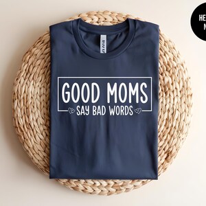 May include: A navy blue t-shirt with the text "GOOD MOMS SAY BAD WORDS" in white lettering.