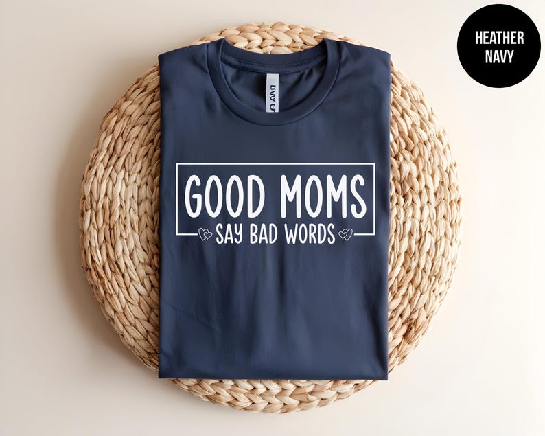 May include: A navy blue t-shirt with the text "GOOD MOMS SAY BAD WORDS" in white lettering.