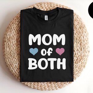 May include: Black t-shirt with white text that reads "MOM of BOTH" with a blue heart and a pink heart.